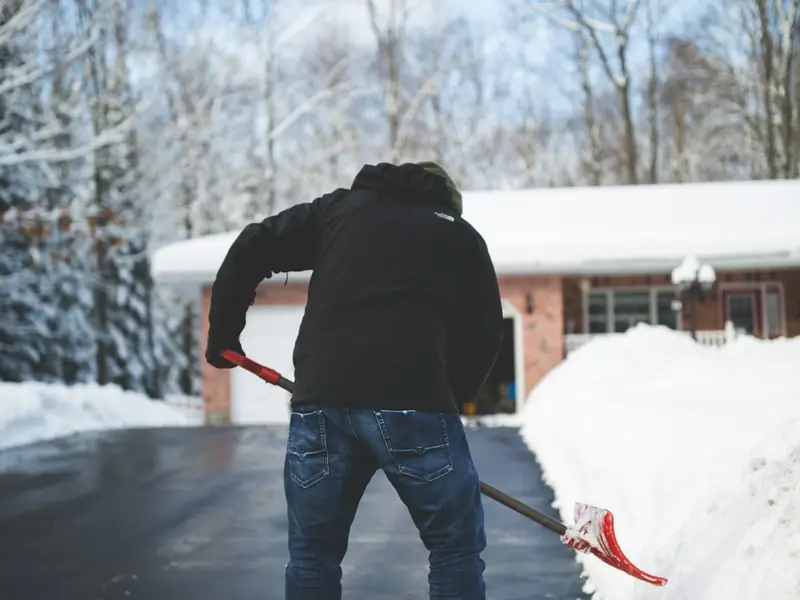 A person shoveling a snowy driveway